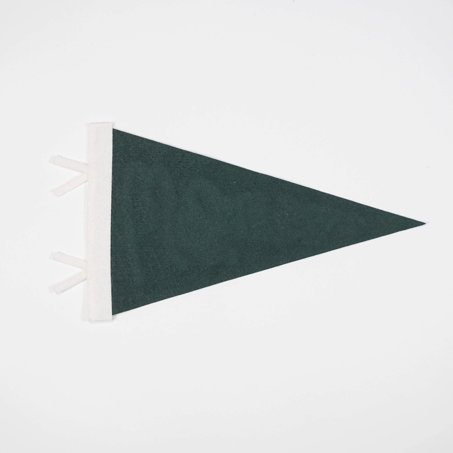 Green triangle-shaped rug with white fringe on a light gray background