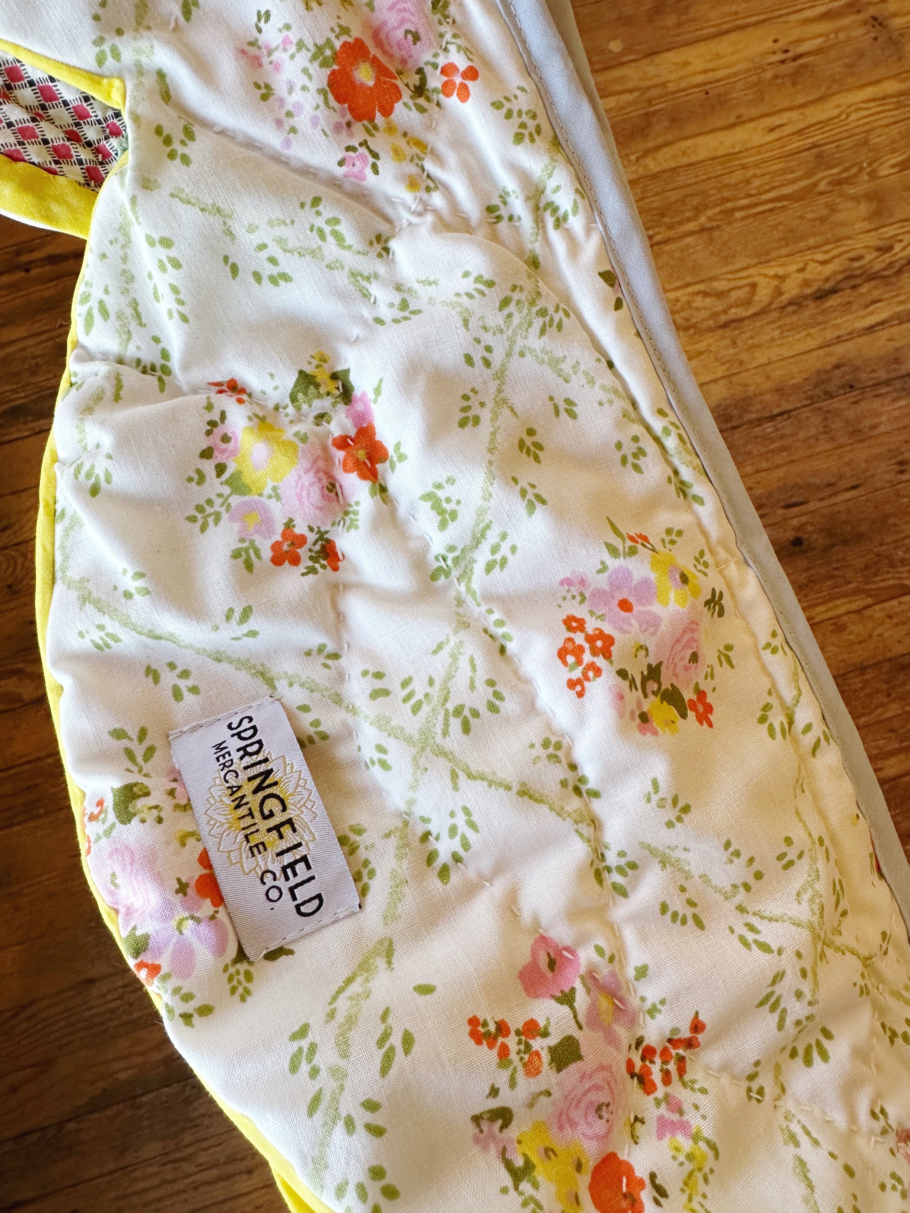 Floral-patterned fabric with a visible brand label on a wooden surface