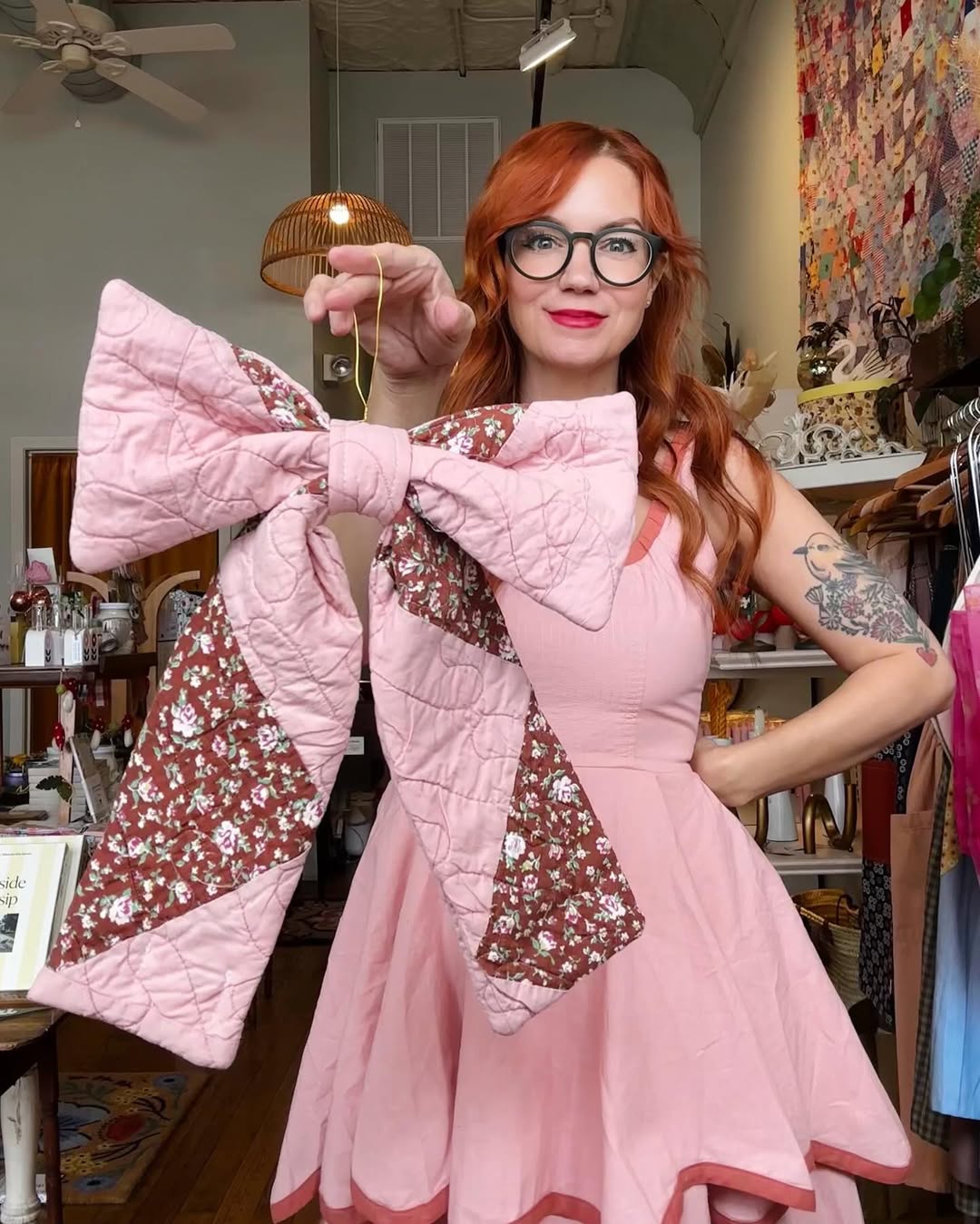 Image of Springfield Mercantile Co. owner Katie Shelton holding a handmade bow made from an antique quilt on the about page. 
Keywords: Springfield Mercantile Co., About Us, Peek Into Our Shop, owner Katie Shelton holding a handmade quilt bow image, online shop, Shopify
