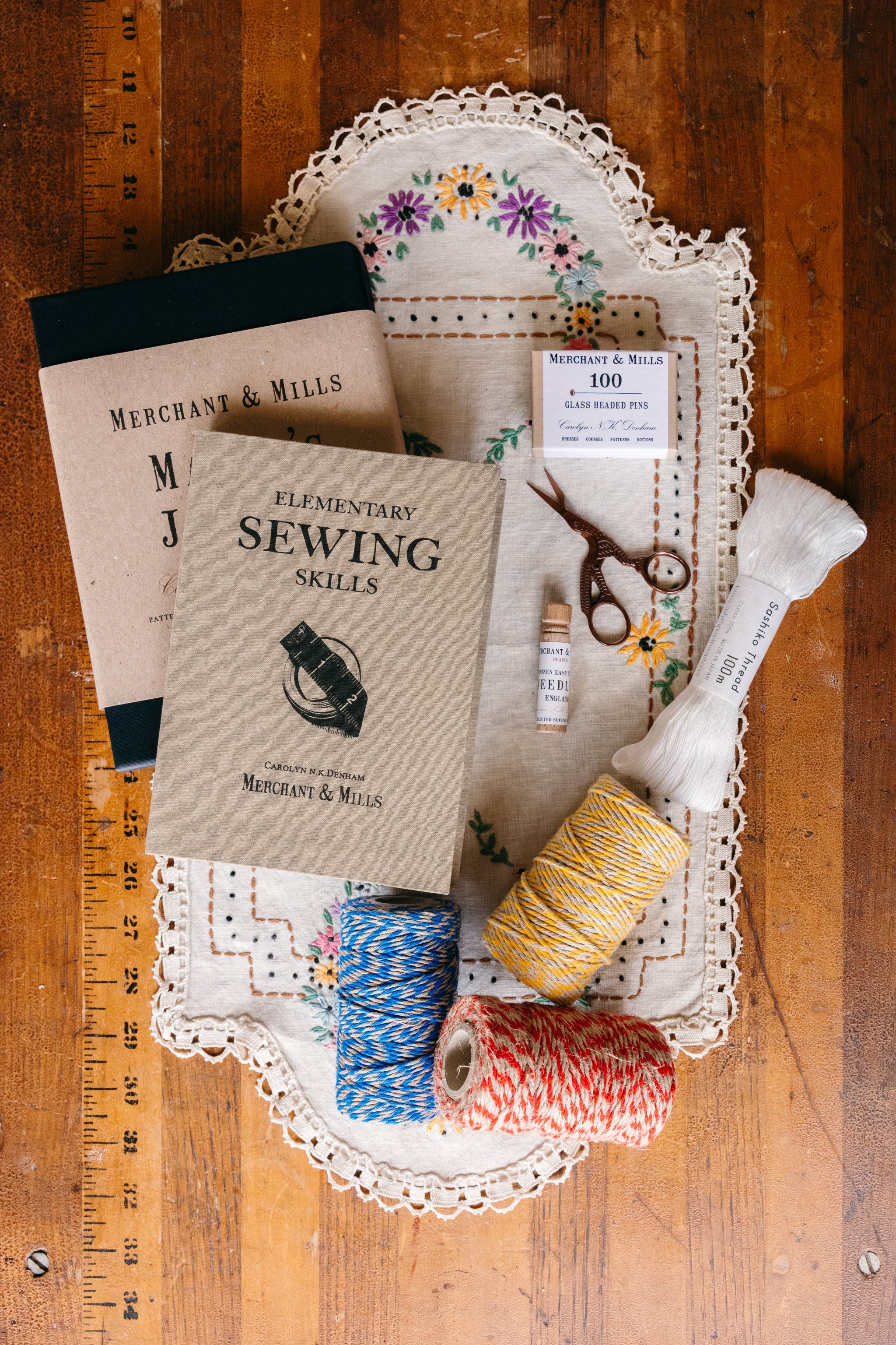 Sewing kit with scissors, needles, thread, and tools on an antique wooden sewing table.

Description: Sliding image card promoting Sewing & Crafts goods on the Springfield Mercantile Co. homepage. 
Keywords: Springfield Mercantile Co., classic sewing and notions, sliding image card, online boutique, Shopify