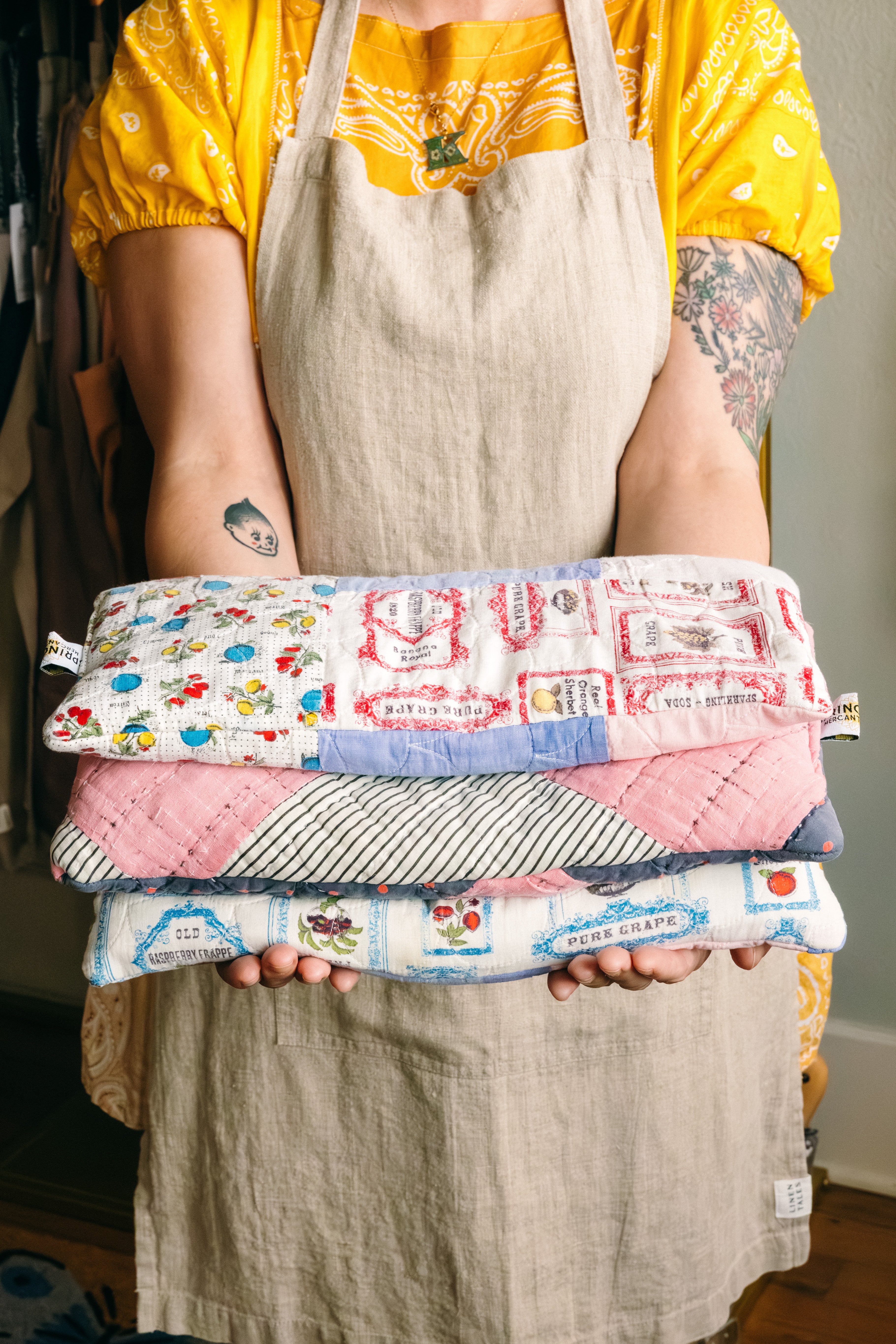 Person holding a stack of three handmade rice sacks made from antique quilts with colorful patterns.

Description: Sliding image card promoting Handmade goods on the Springfield Mercantile Co. homepage. 
Keywords: Springfield Mercantile Co., handmade, sliding image card, online shop, Shopify